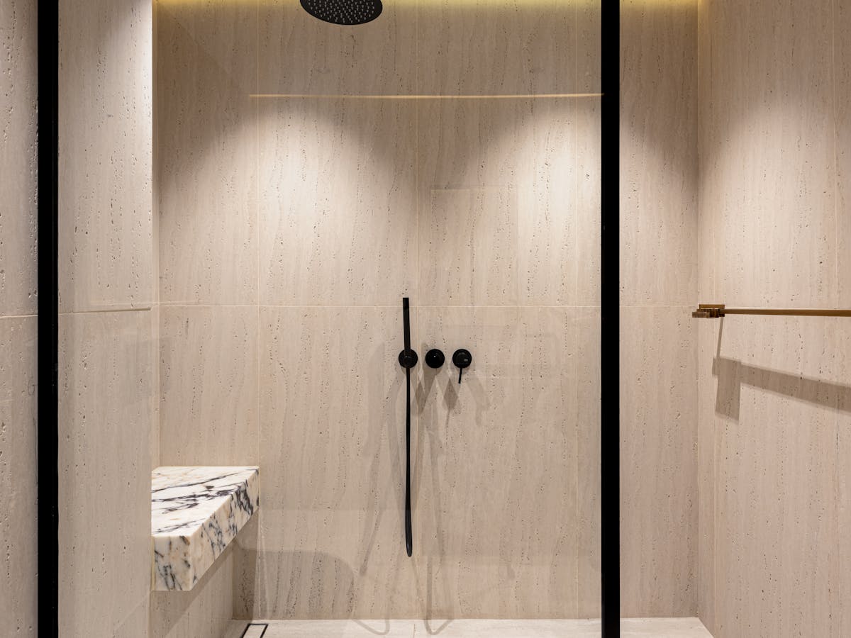 Bagno spa naturale con doccia walk-in in travertino e illuminazione LED